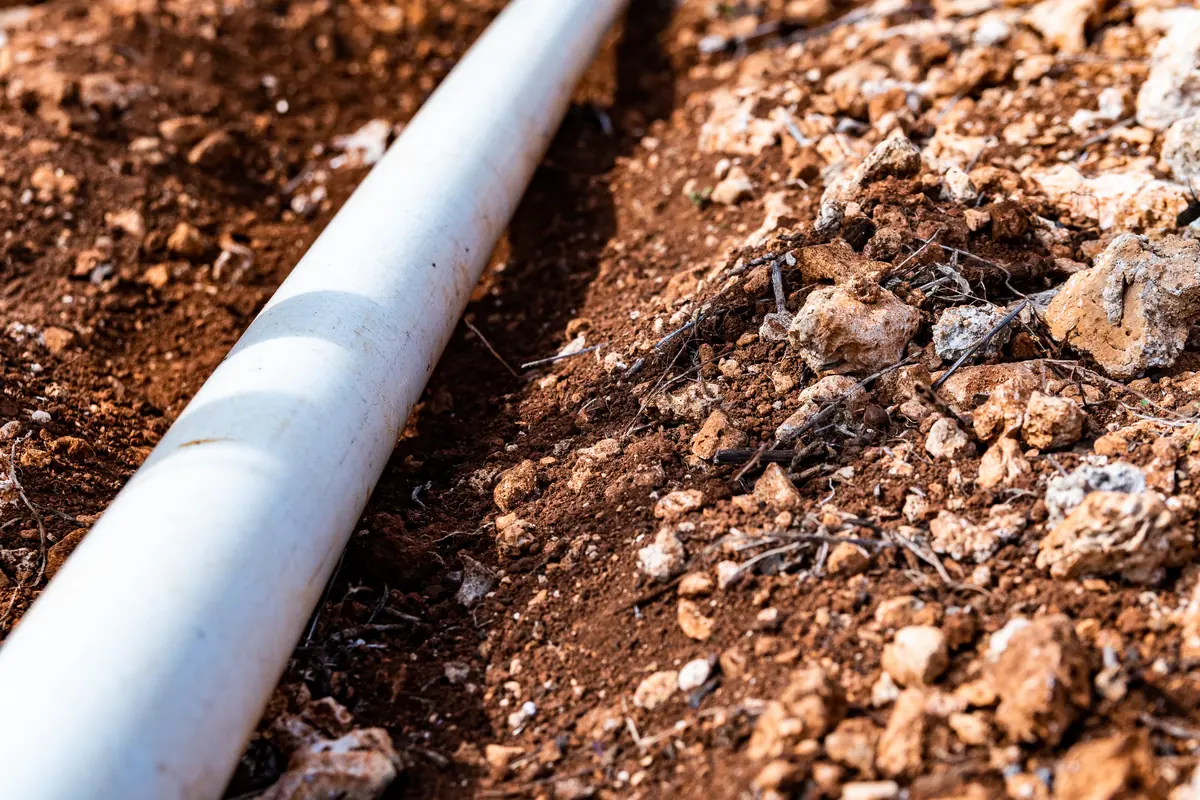 New PVC pipe laid in a dirt trench