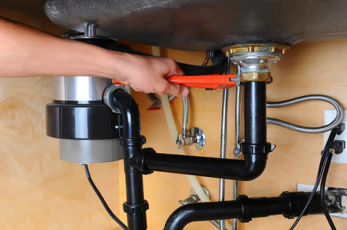 Tightening a kitchen sink drain connection with a pipe wrench